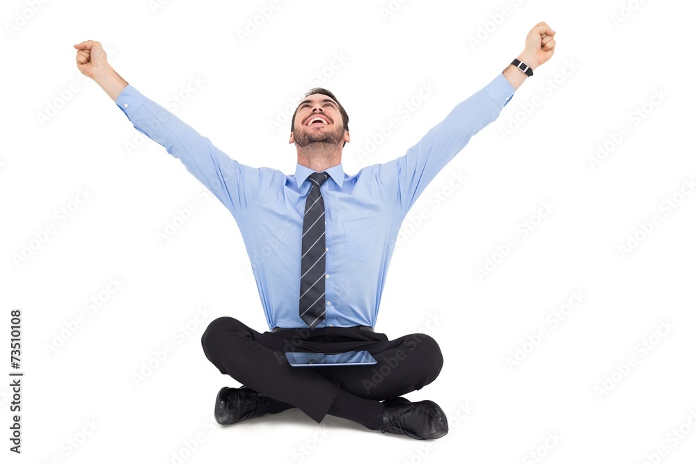 Businessman cheering with tablet sitting on floor Businessman cheering with tablet sitting on floor