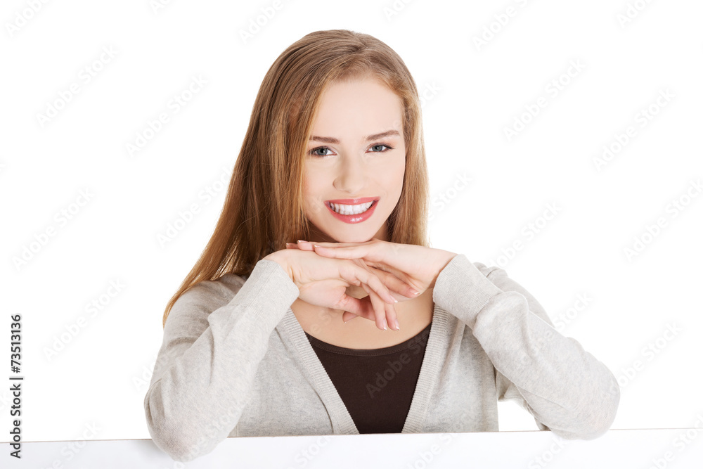 Blond woman with hand on chin sitting at the desk