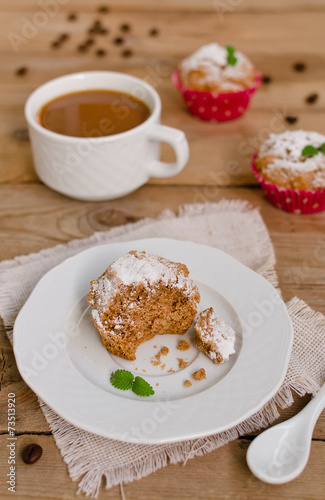 Muffins with coffee on wooden background
