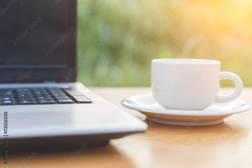 A cup of coffee and laptop on the table A cup of coffee and laptop on the table