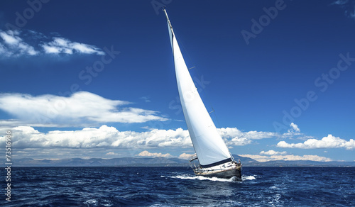 Fotografia Sailing ship yachts with white sails in the open sea.