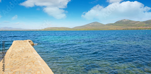 rocky pier under soft clouds