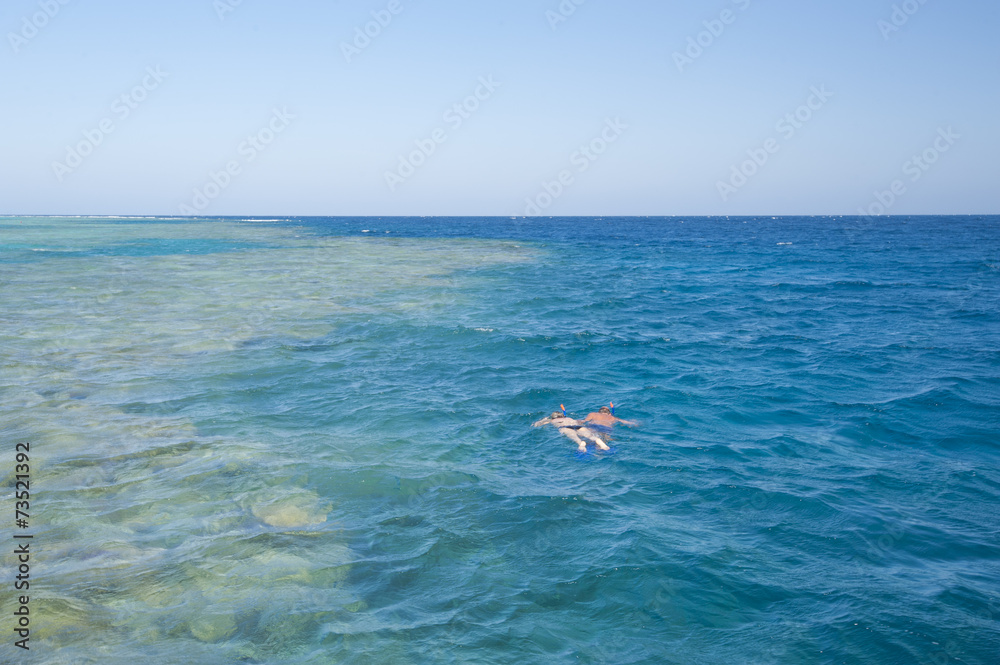Couple snorkeling on tropical reef