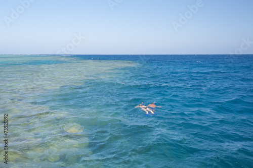 Couple snorkeling on tropical reef