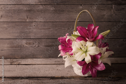 lily in basket on wooden background