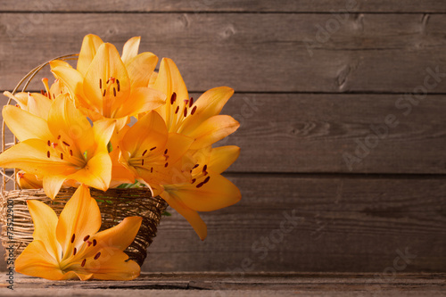 Fototapeta Naklejka Na Ścianę i Meble -  lily in basket on wooden background