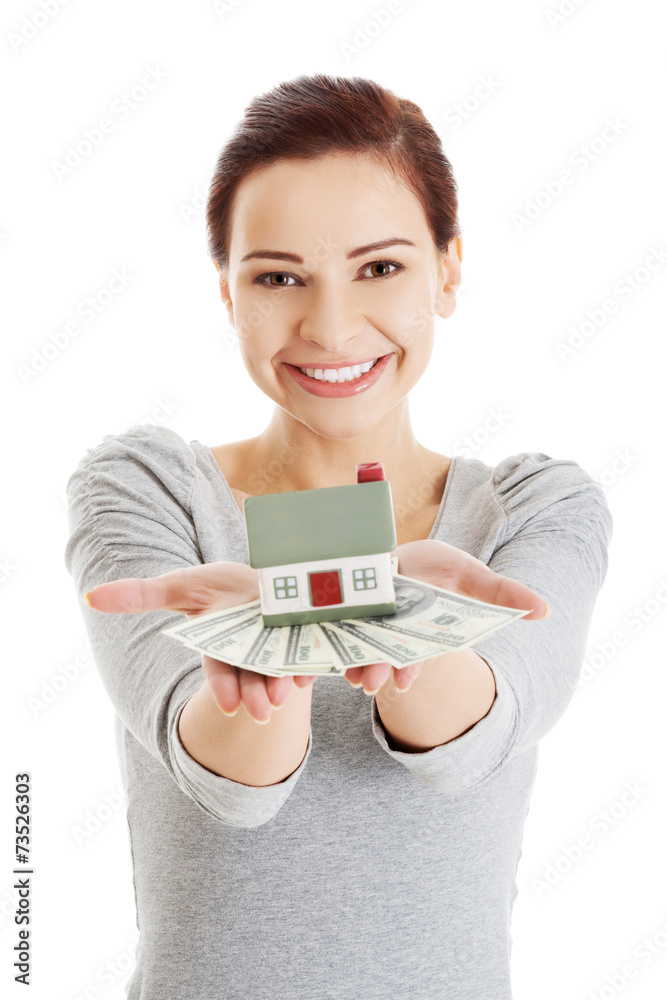 Happy woman holding house model and dollar bills Happy woman holding house model and dollar bills