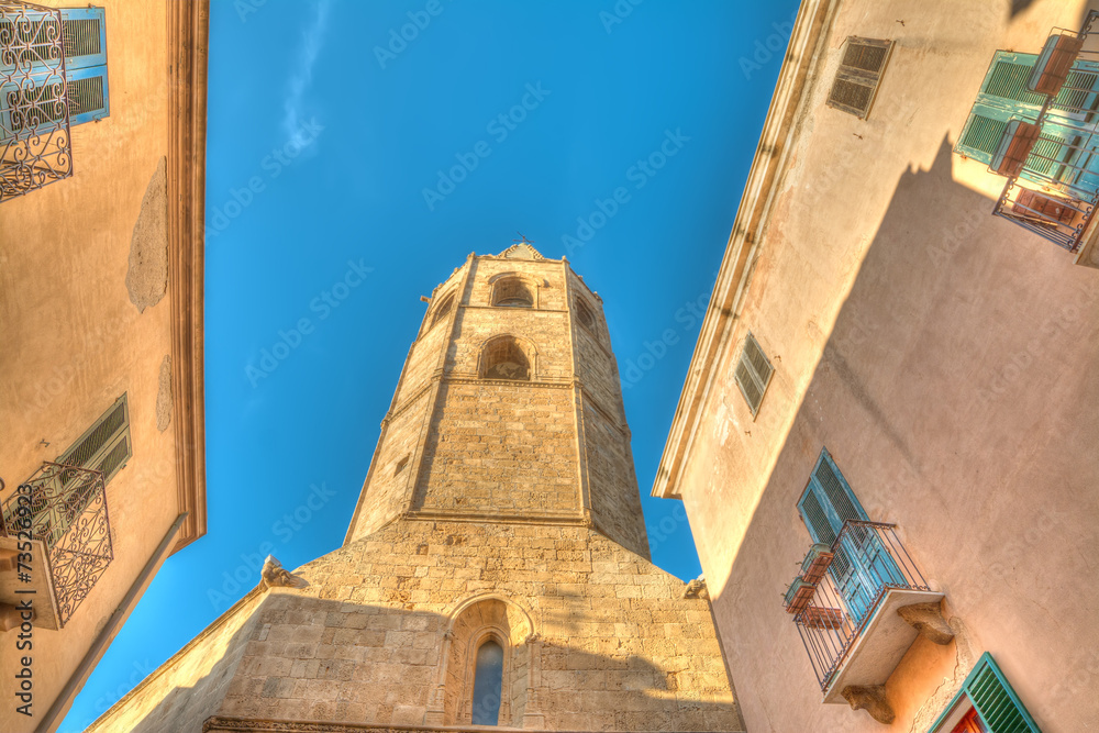 Alghero Duomo steeple under a blue sky