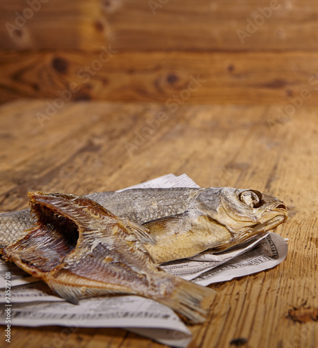 Russian snack . Dried fish on old newspaper