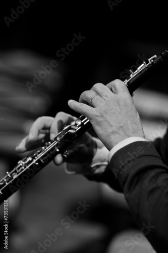 Hands of man playing the oboe in black and white