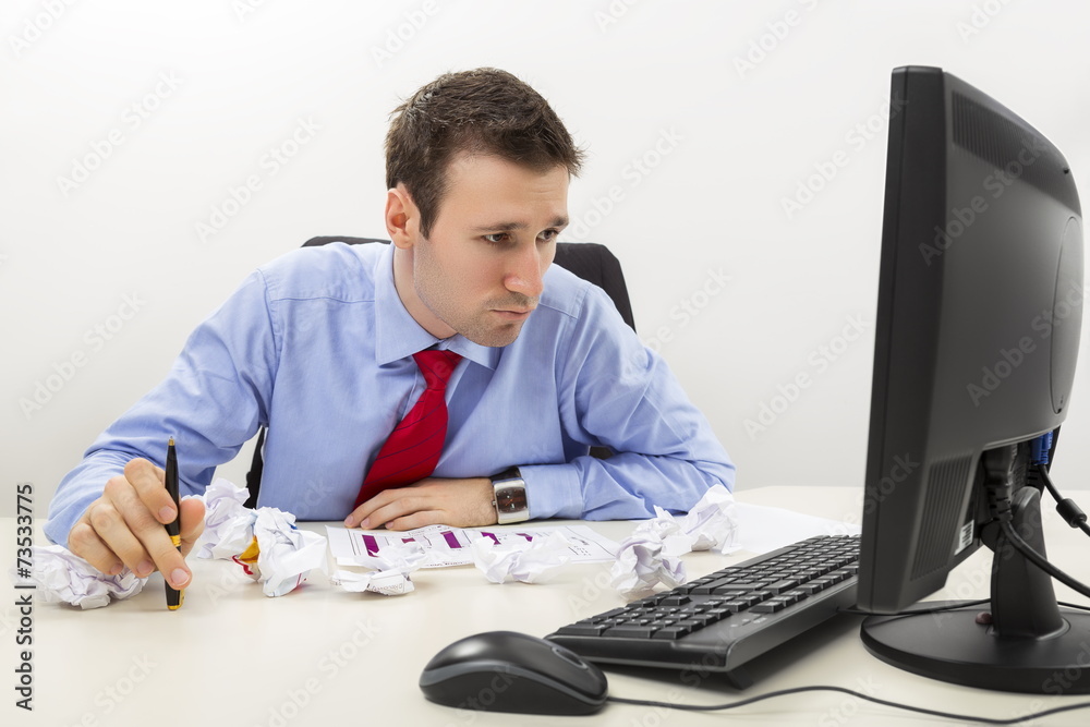 Worried business man with crumpled paper sheets on desk Worried business man with crumpled paper sheets on desk