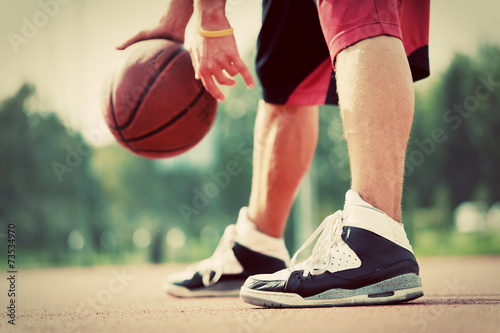 Young man on basketball court dribbling with bal
