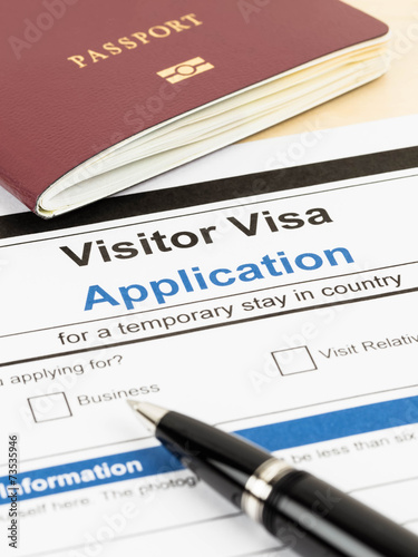Visa application form with passport and pen