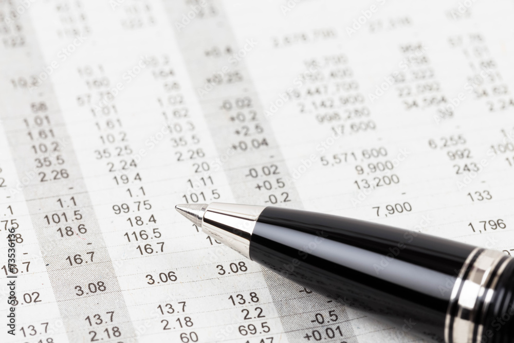 Pen rest on stock price detail financial newspaper Pen rest on stock price detail financial newspaper