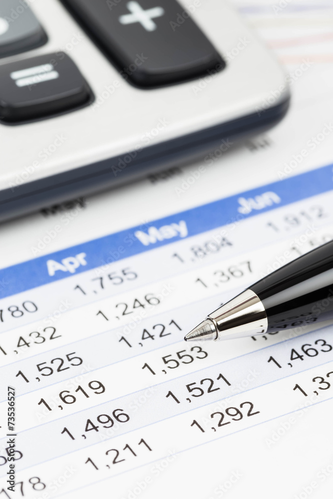 Finance report analysis with pen, and calculator Finance report analysis with pen, and calculator