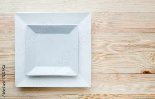 Konstfotografi Square white plates over wooden table