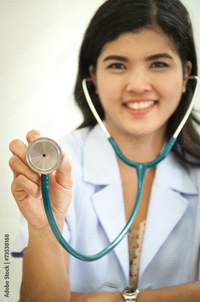 Happy female doctor holding out stethoscope