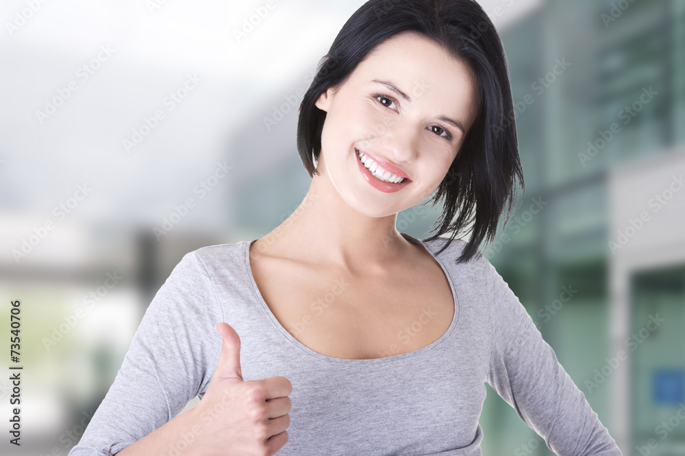 Beautiful young woman gesturing thumbs up.