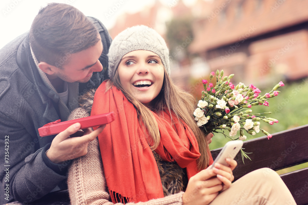 Obraz premium Man giving surprise gift to woman in the park