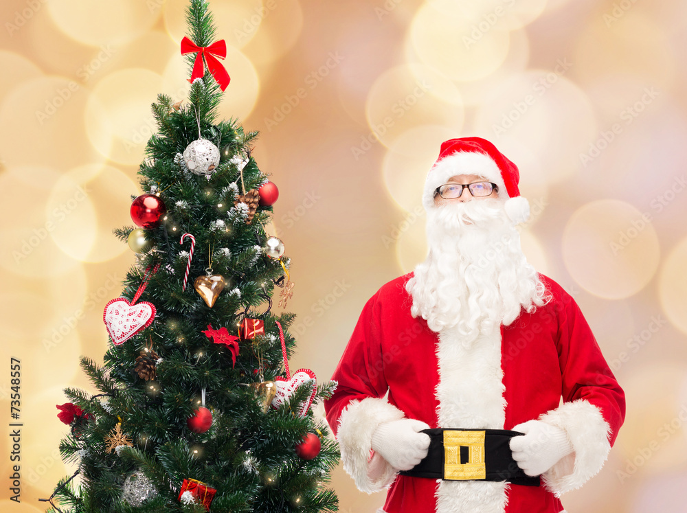 man in costume of santa claus with christmas tree man in costume of santa claus with christmas tree