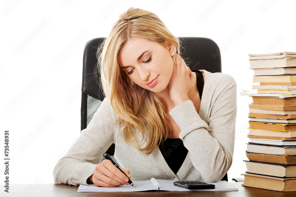 Woman preparing to exam, counting on calculator Woman preparing to exam, counting on calculator