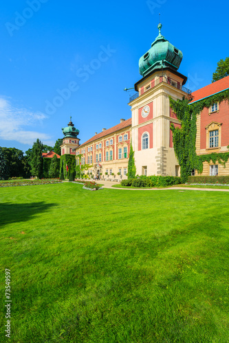 Green gardens of Lancut castle on sunny summer day, Poland