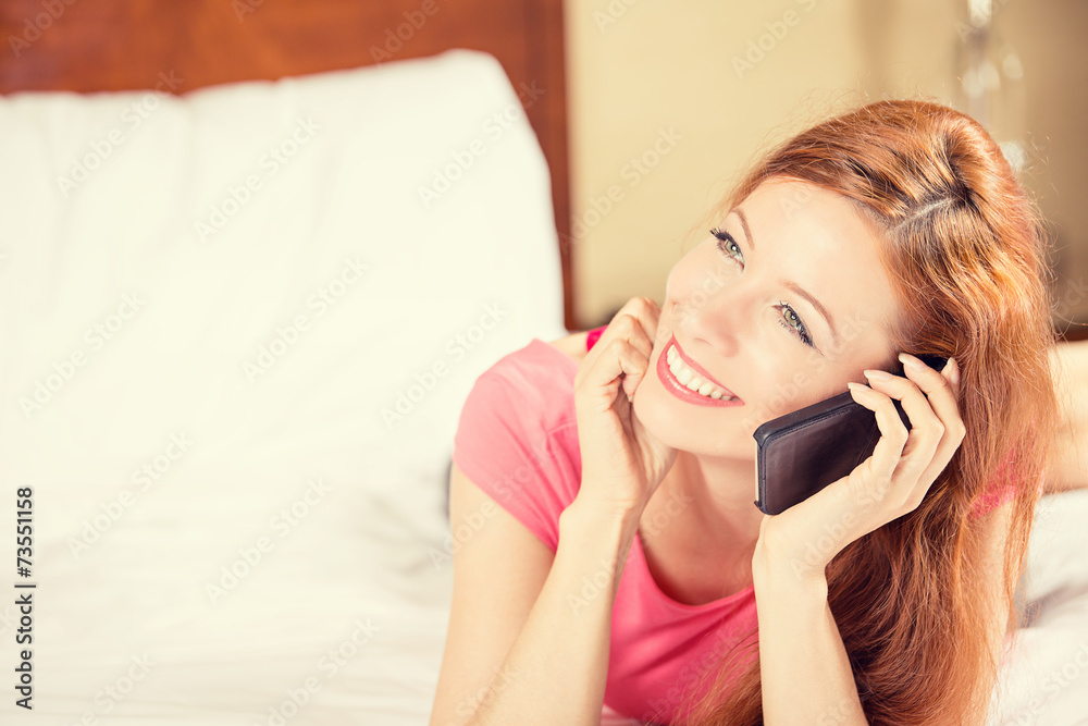 happy young smiling woman using mobile phone lying in bed happy young smiling woman using mobile phone lying in bed