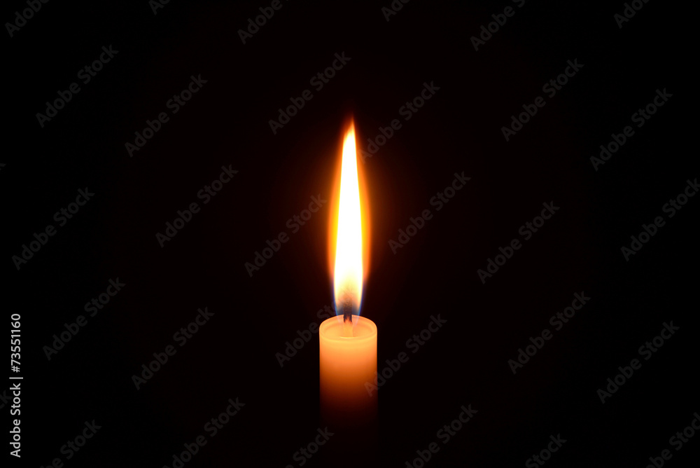 White candle burning on a black background White candle burning on a black background
