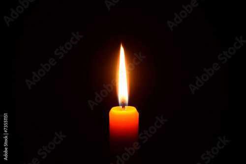 Orange candle burning on a black background