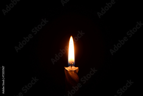 Silver candle burning on a black background