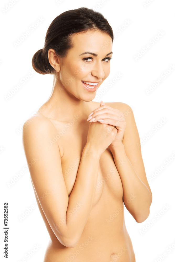 Portrait of happy nude woman covering her breast