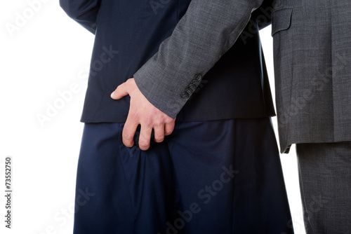 Businessman holding hand on partners ass