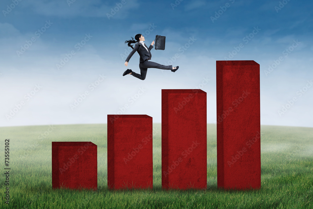 Businesswoman is jumping on business graph Businesswoman is jumping on business graph