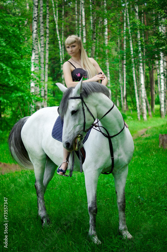 Girl and horse walking in the woods