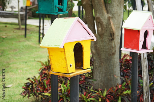 yellow wooden bird house in garden