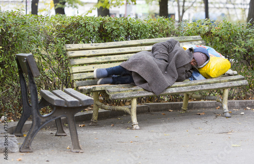 Homeless man sleeping on a bench