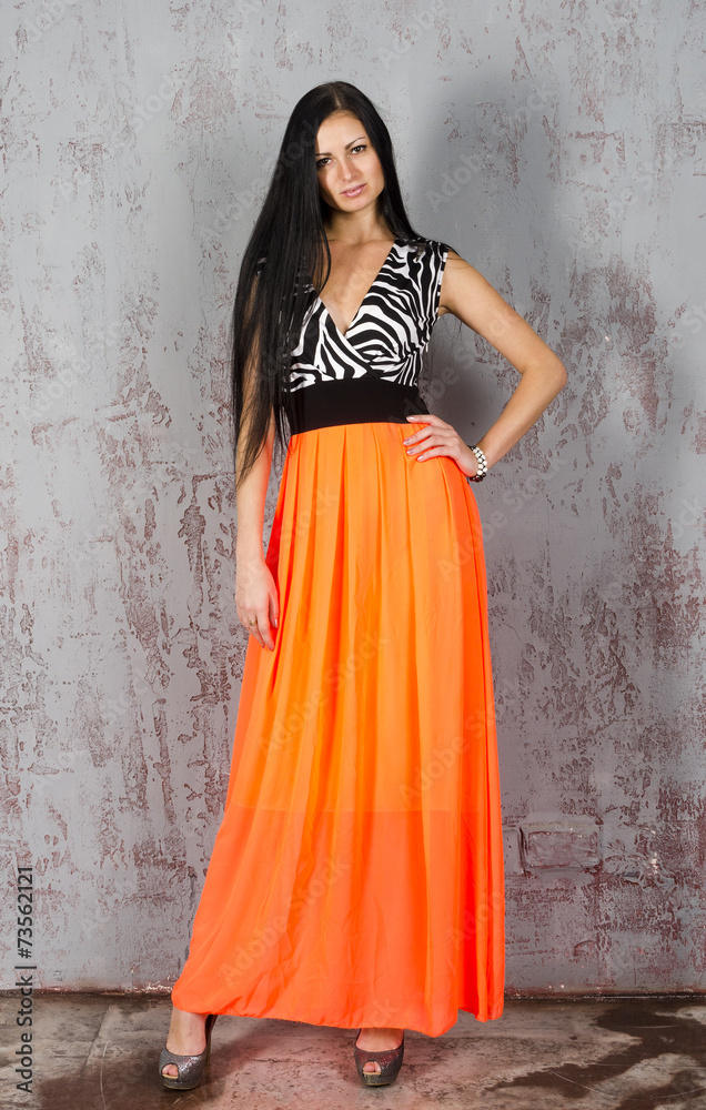 Young brunette woman in long orange skirt Young brunette woman in long orange skirt