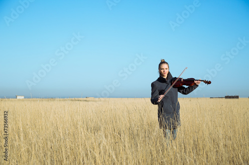 The girl with a violin on the field