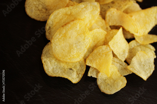 potato chips against black background