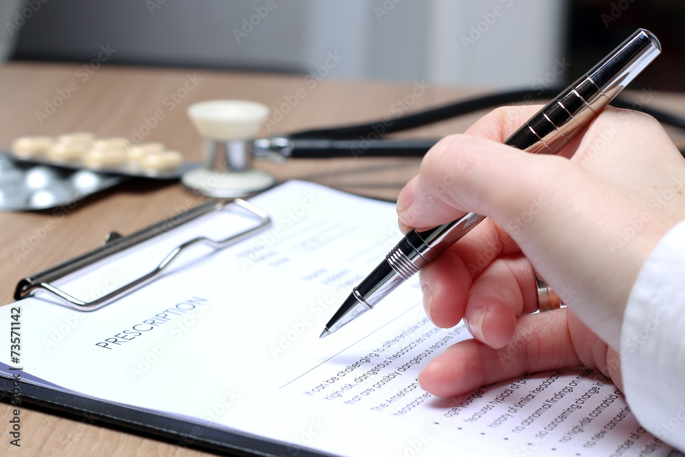 Doctor in a white labcoat writing out RX prescription Doctor in a white labcoat writing out RX prescription