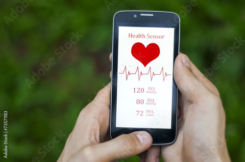 Male hand holding a phone with pressure and heart rate screen