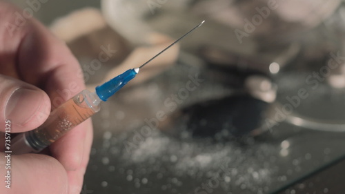 Drug syringe and cooked heroin on spoon HD