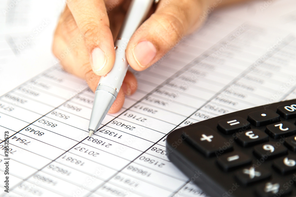 Close up woman hand holding pen on spreadsheet Close up woman hand holding pen on spreadsheet