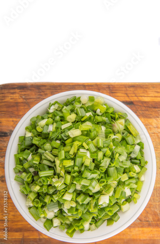 Chopped scallion or spring onion leaves in a white bowl