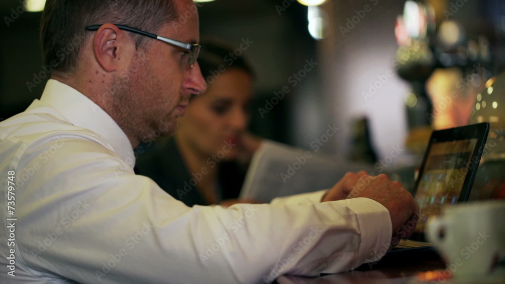 Businessman working on laptop in the pub, steadycam shot Businessman working on laptop in the pub, steadycam shot