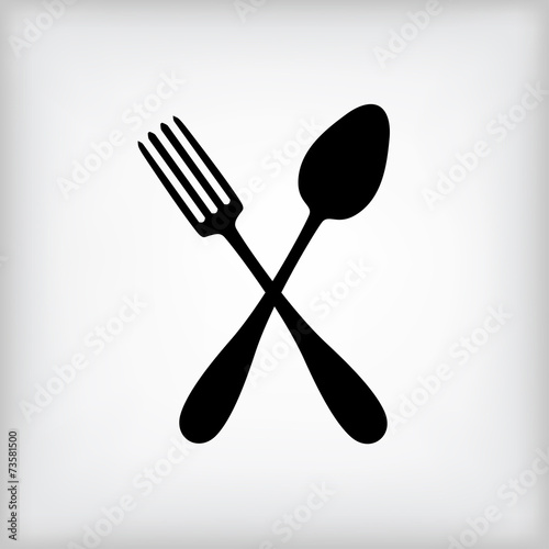 Crossed spoon and fork on gray background