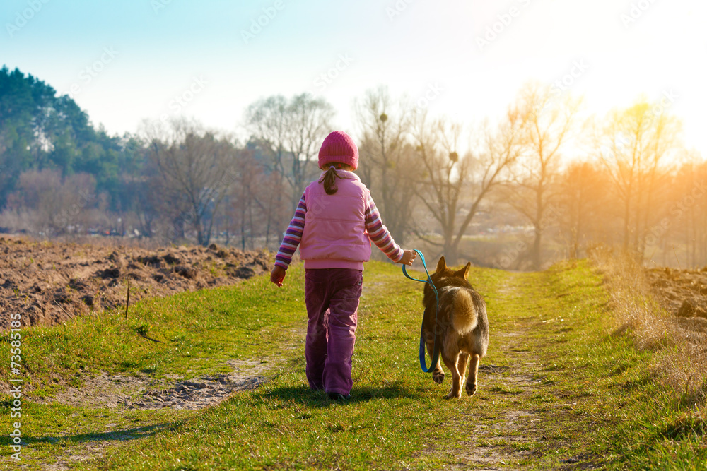Little girl walking with dog and keeping the dog on leash Little girl walking with dog and keeping the dog on leash