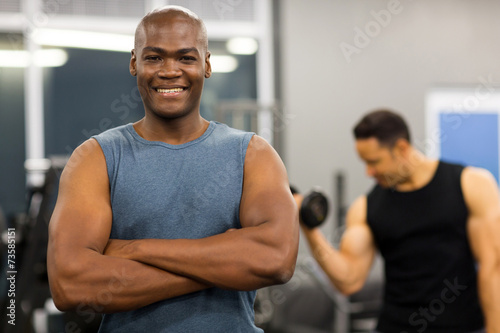 young african man with arms folded in gym