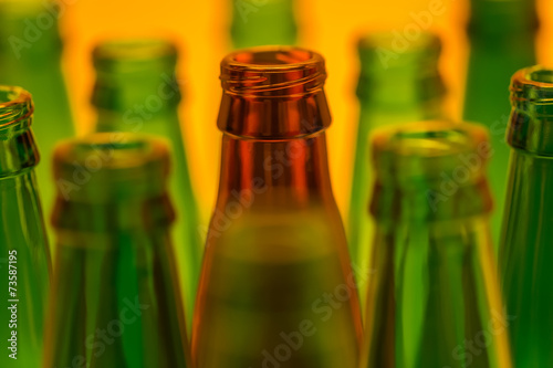 Ten Empty Beer Bottles Shot with Orange Light.