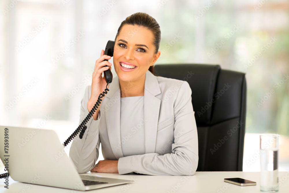 young businesswoman talking on landline phone young businesswoman talking on landline phone